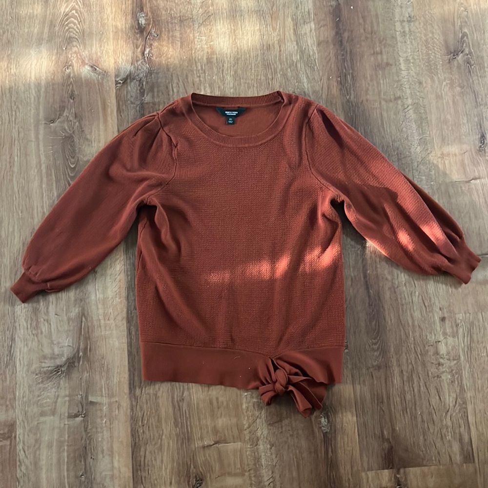 Dark burnt orange sweater, bow detailing at bottom